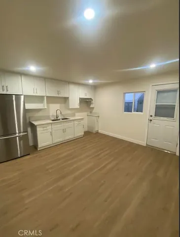 a kitchen with refrigerator and white cabinets