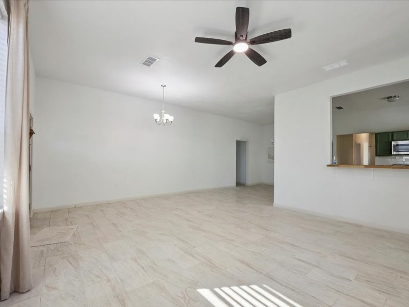 2290 Orange Avenue Beaumont, TX 77701 - Photo 3 of 12 an empty room with ceiling fan and windows