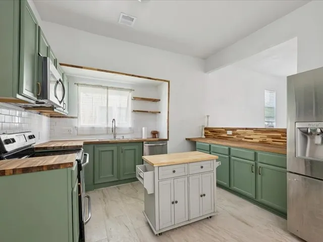 a kitchen with a stove sink and cabinets