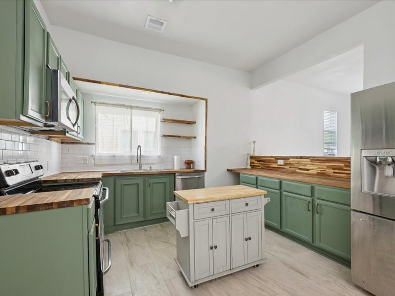 2290 Orange Avenue Beaumont, TX 77701 - Photo 4 of 12 a kitchen with a stove sink and cabinets