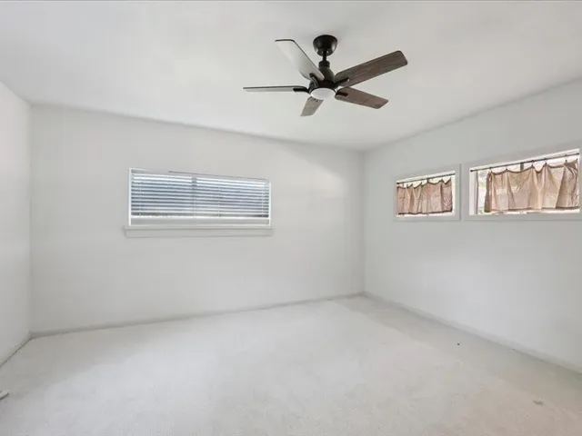 a view of a big room with wooden floor and windows