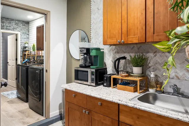 a kitchen with sink refrigerator dining table and chairs