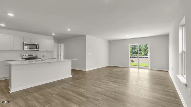 a view of kitchen with microwave a stove and wooden floor