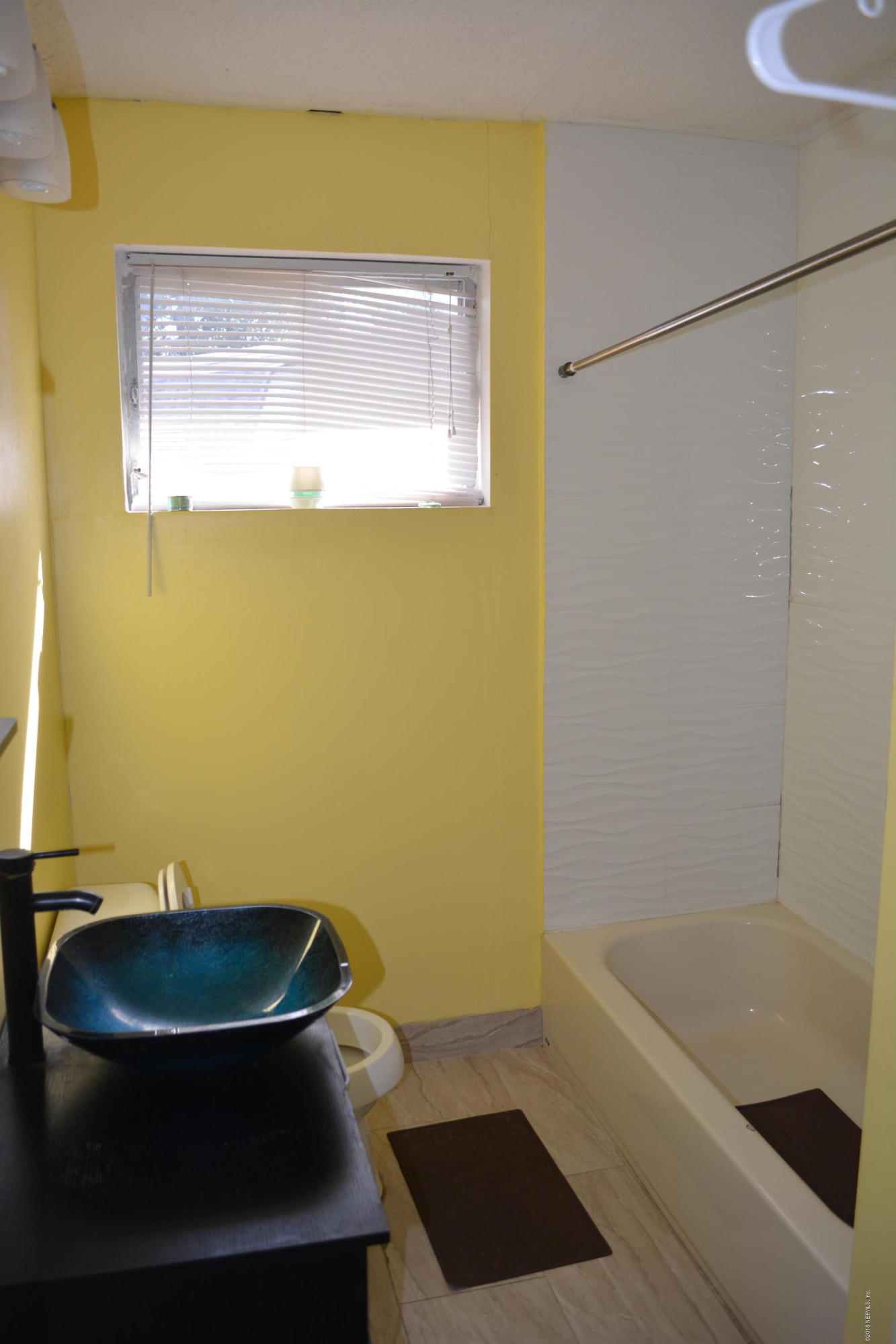 3235 Rogero Road Jacksonville, FL 32277 - Photo 11 of 20 a bathroom with a sink and a mirror