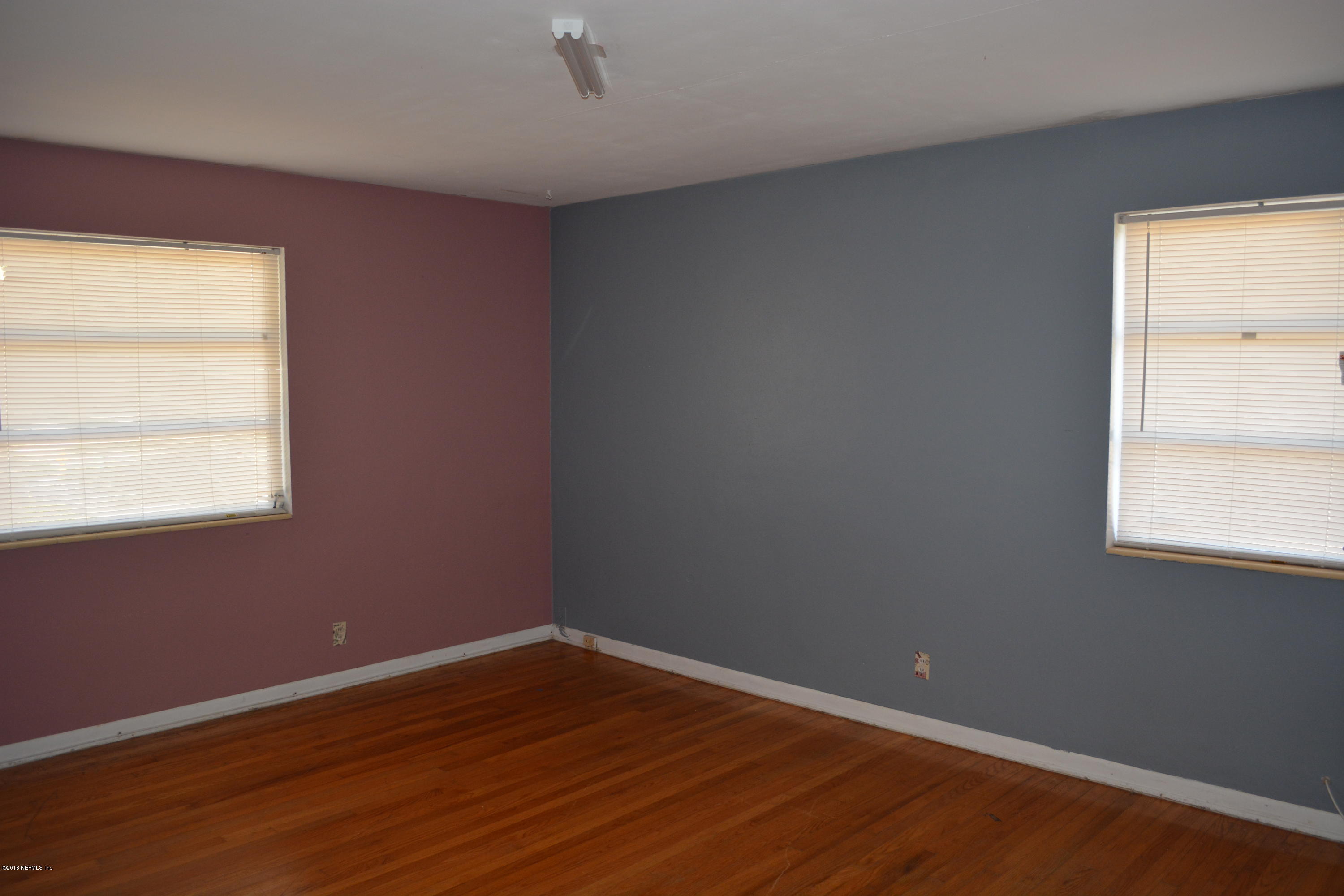 3235 Rogero Road Jacksonville, FL 32277 - Photo 13 of 20 an empty room with wooden floor and windows