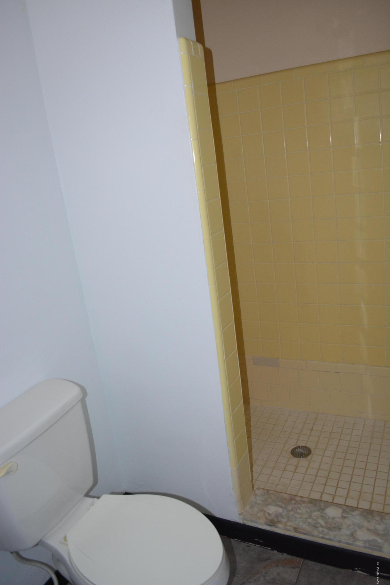 3235 Rogero Road Jacksonville, FL 32277 - Photo 14 of 20 a white toilet sitting next to a shower