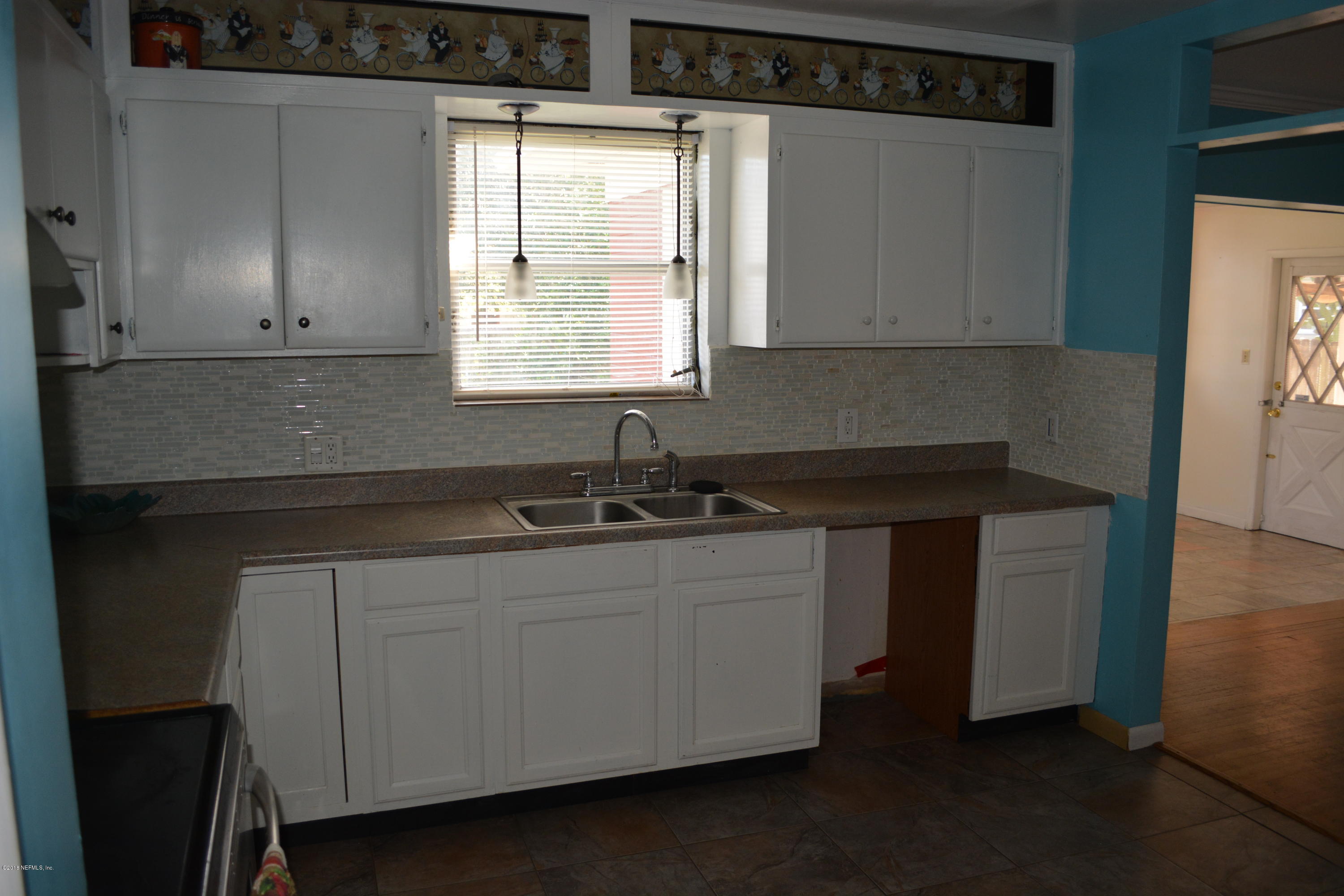3235 Rogero Road Jacksonville, FL 32277 - Photo 6 of 20 a kitchen with stainless steel appliances a sink stove and window