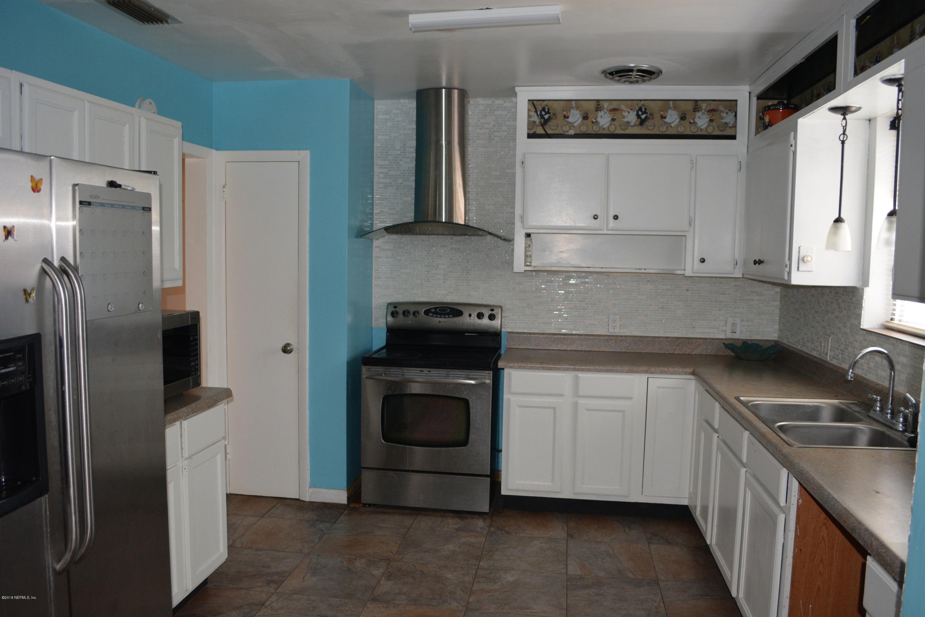 3235 Rogero Road Jacksonville, FL 32277 - Photo 7 of 20 a kitchen with stainless steel appliances a refrigerator sink and white cabinets