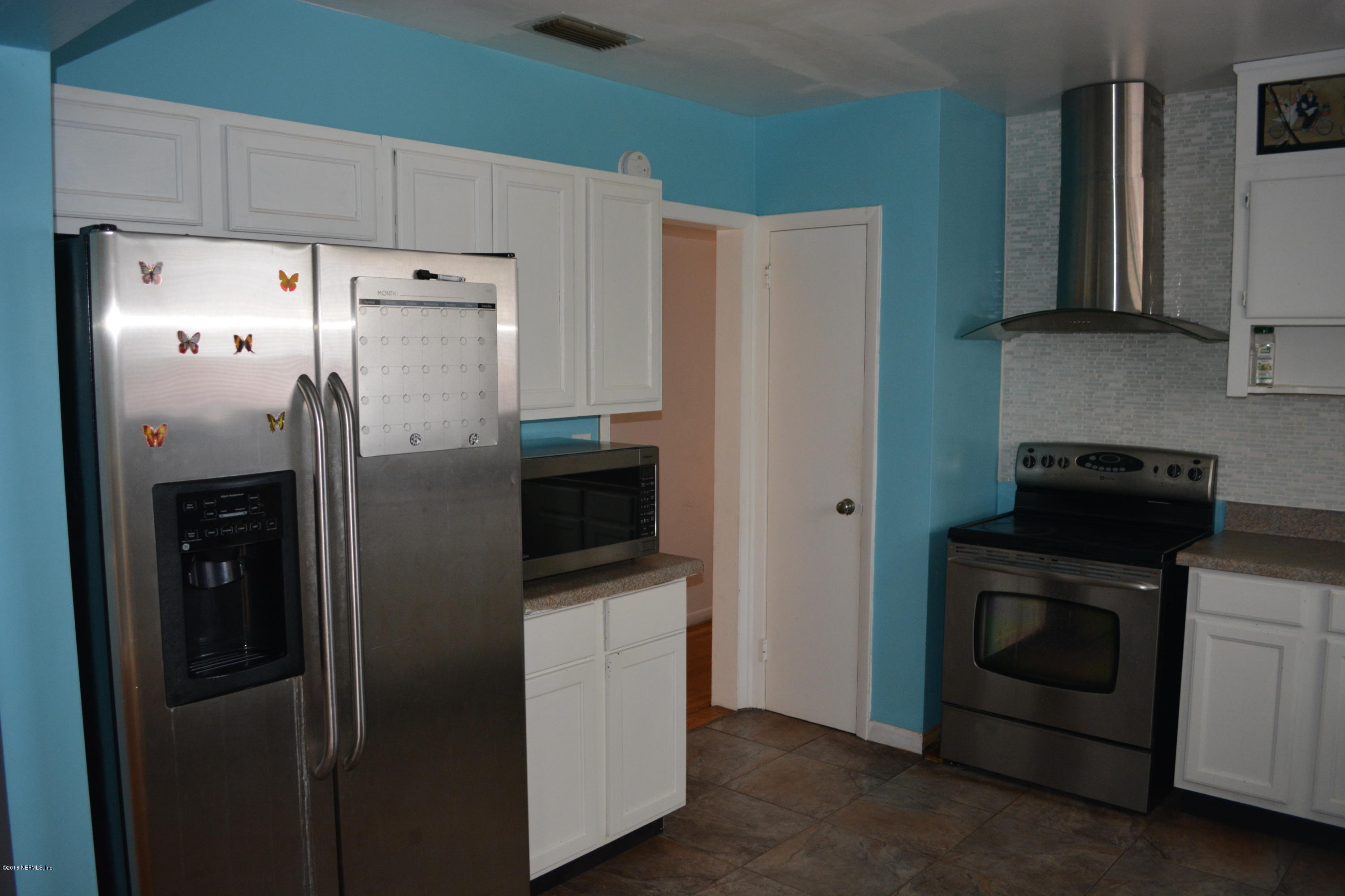 3235 Rogero Road Jacksonville, FL 32277 - Photo 8 of 20 a kitchen with stainless steel appliances a refrigerator a stove a sink and cabinets