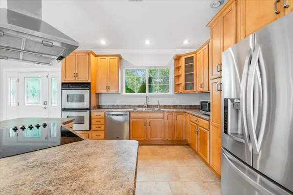a kitchen with a refrigerator sink and cabinets