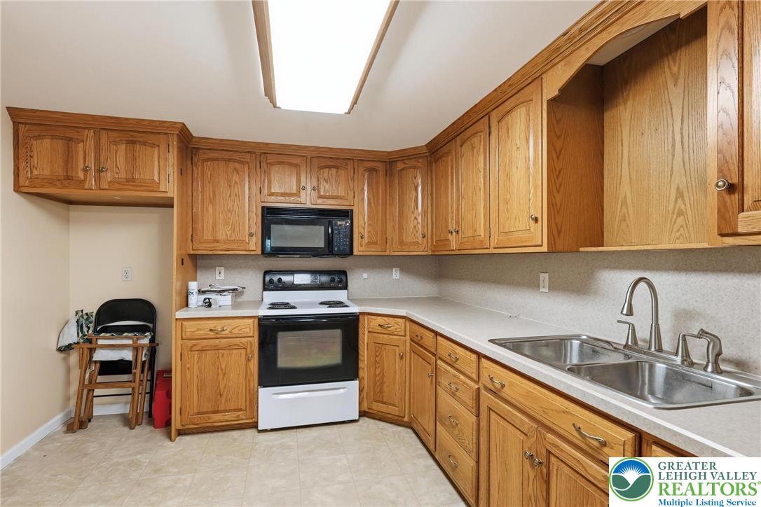 5217 Cider Press Road Schnecksville, PA 18078 - Photo 41 of 54 a kitchen with stainless steel appliances granite countertop a sink stove and microwave
