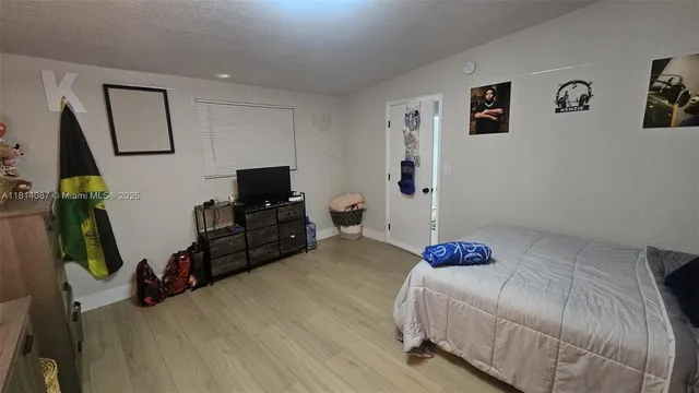 a bedroom with a bed and a flat tv screen on the dresser
