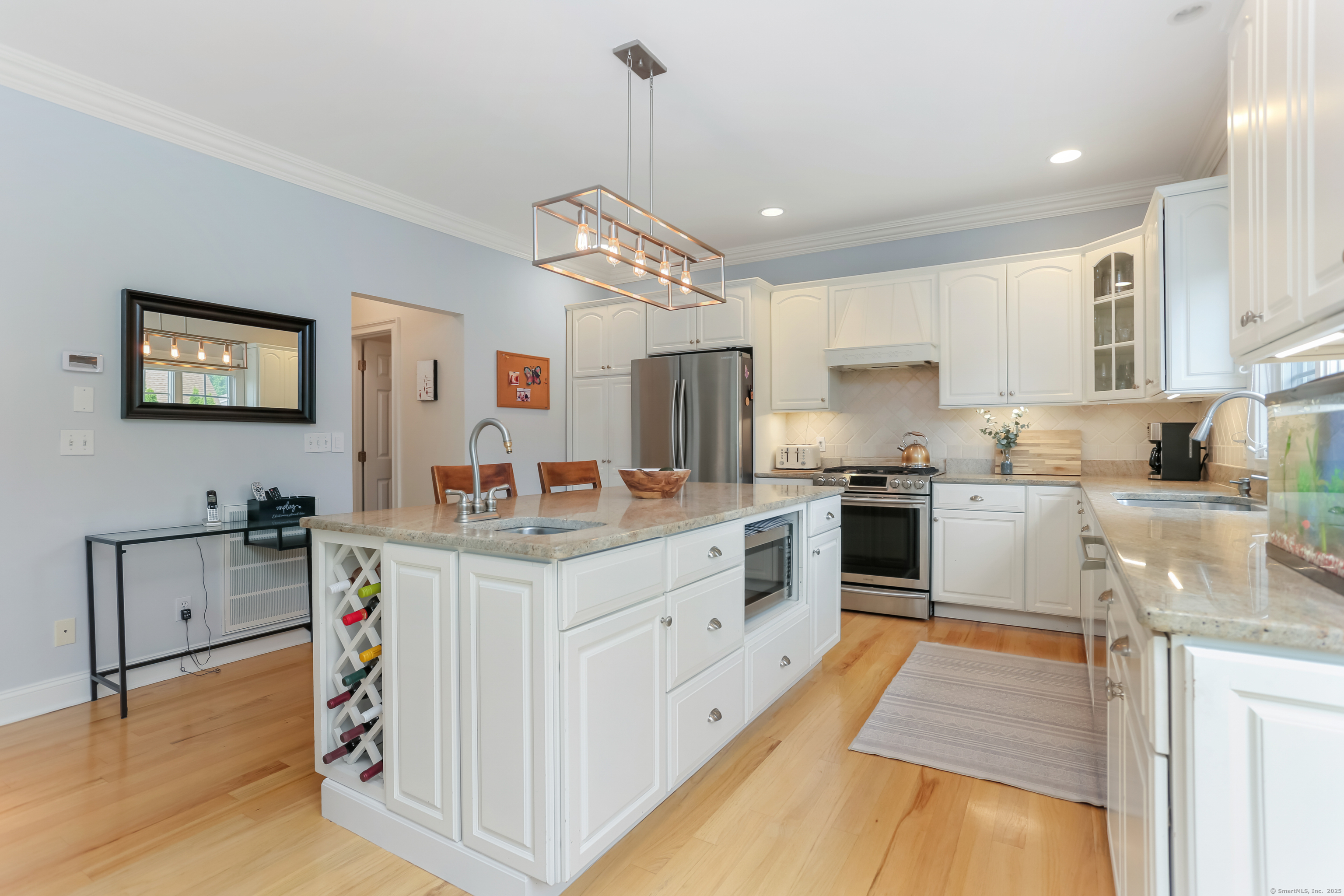 162 Country Road, Unit 162 Fairfield, CT 06824 - Photo 12 of 33 a large kitchen with kitchen island a large counter space a sink appliances and cabinets