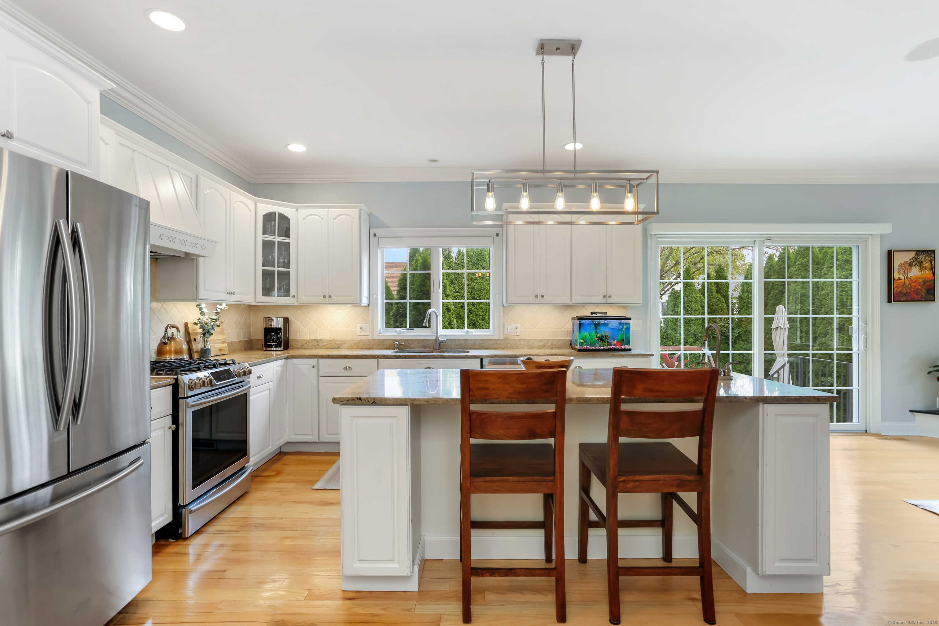 162 Country Road, Unit 162 Fairfield, CT 06824 - Photo 14 of 33 a kitchen with stainless steel appliances granite countertop a table chairs refrigerator and sink