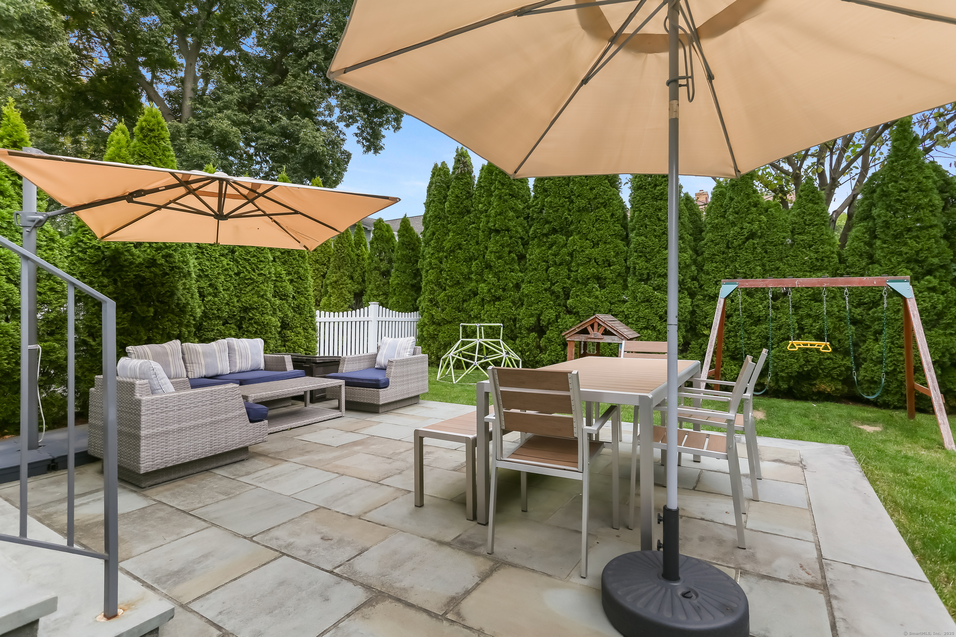 162 Country Road, Unit 162 Fairfield, CT 06824 - Photo 28 of 33 a view of a patio with a table and chairs under an umbrella