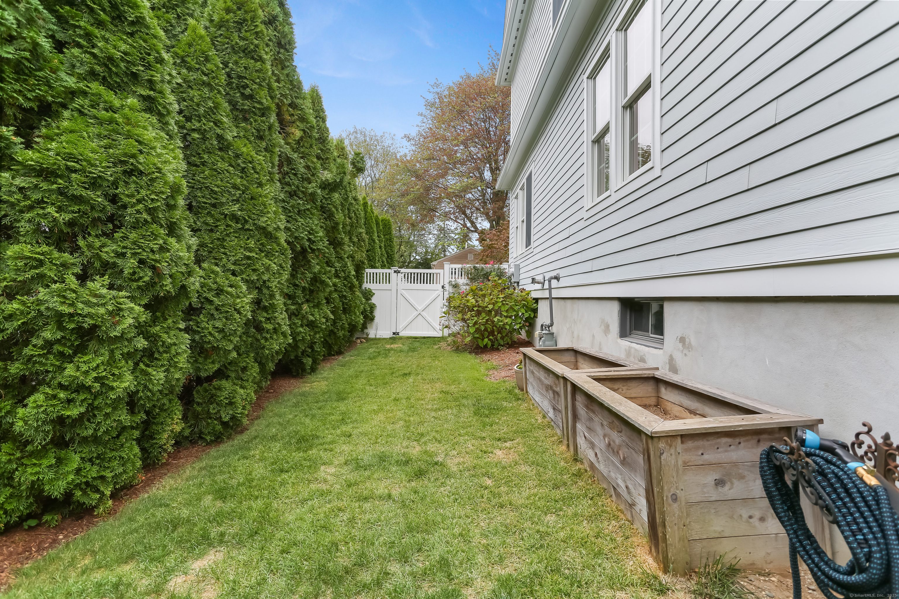 162 Country Road, Unit 162 Fairfield, CT 06824 - Photo 29 of 33 a backyard of a house with table and chairs