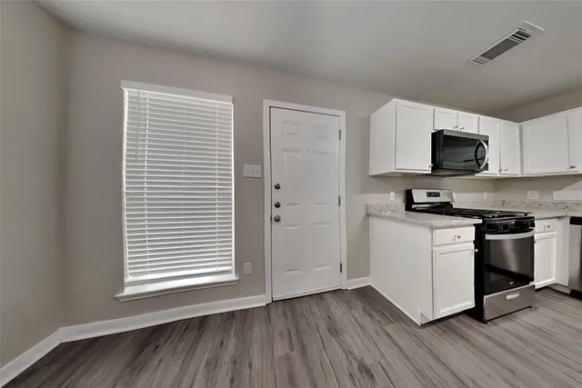 a kitchen with wooden floors and a stove