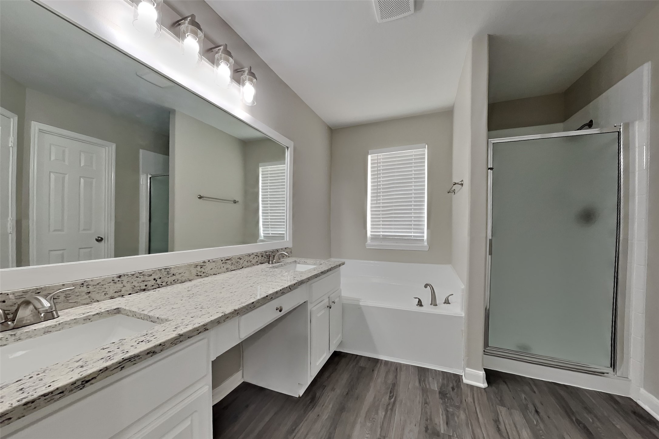 19710 Ringwald Court Spring, TX 77379 - Photo 10 of 20 a bathroom with a granite countertop double vanity sink a mirror and bathtub