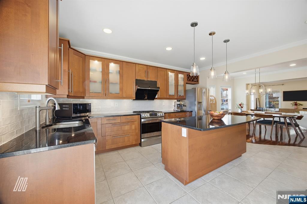 331 Undercliff Avenue Edgewater, NJ 07020 - Photo 16 of 45 a large kitchen with kitchen island a stove a sink a counter top space and living room view