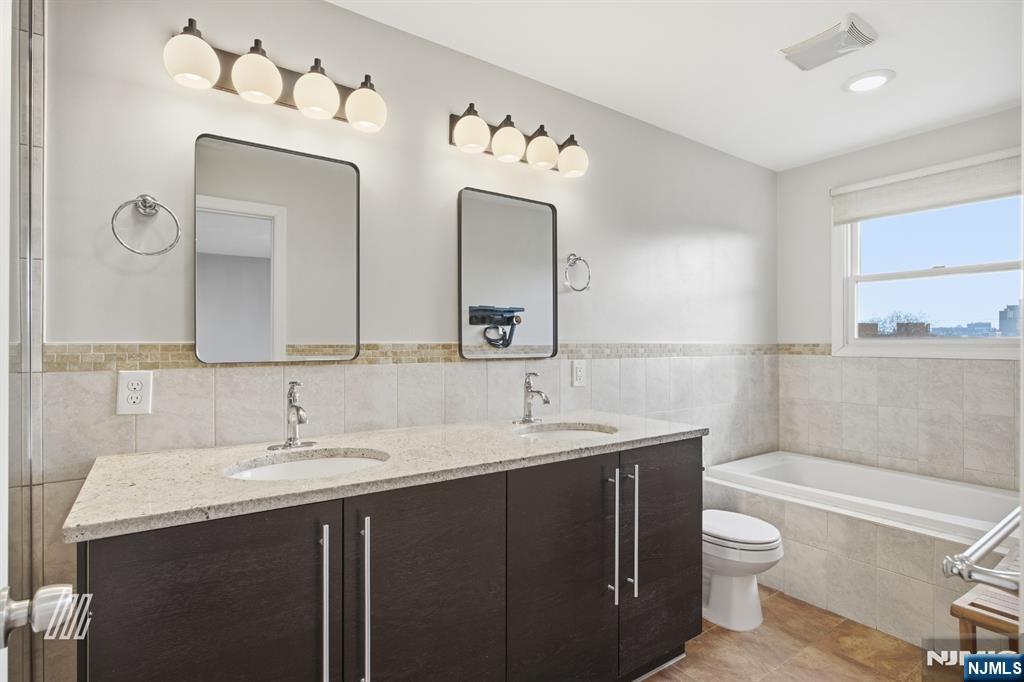 331 Undercliff Avenue Edgewater, NJ 07020 - Photo 26 of 45 a bathroom with a double vanity sink mirror and toilet