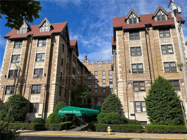 a front view of a residential apartment building with a yard