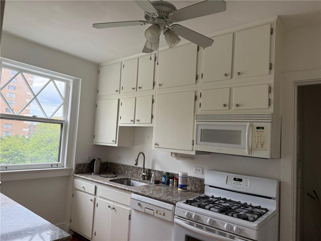 166 North Dithridge Street, Unit 2A Pittsburgh, PA 15213 - Photo 13 of 32 a kitchen with granite countertop white cabinets stainless steel appliances and a window