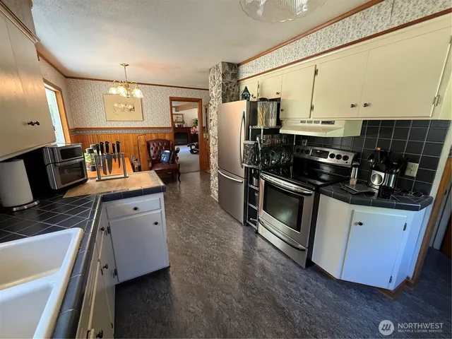 a kitchen with stainless steel appliances granite countertop a refrigerator and a stove