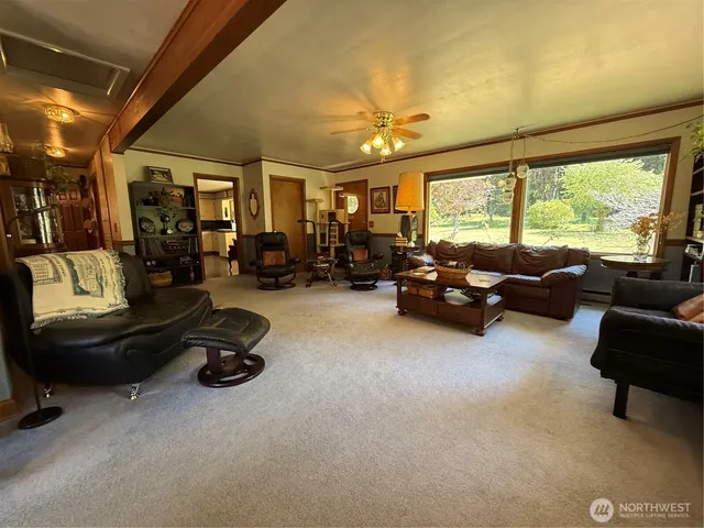 a living room with furniture a flat screen tv and a window