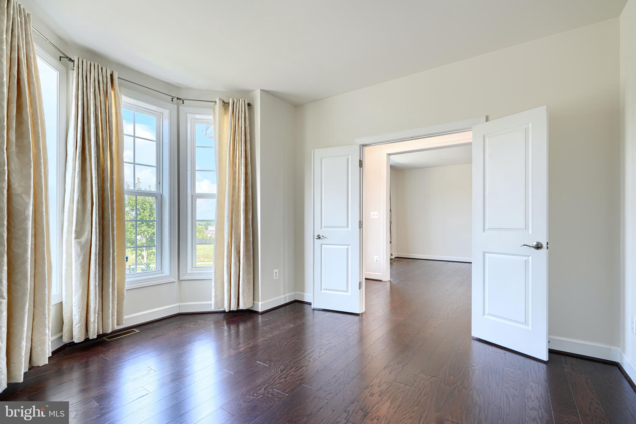 10819 White Trillium Road Perry Hall, MD 21128 - Photo 5 of 47 an empty room with wooden floor and windows
