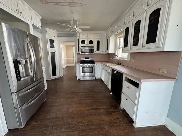 a kitchen with stainless steel appliances granite countertop a refrigerator a stove top oven a sink and dishwasher