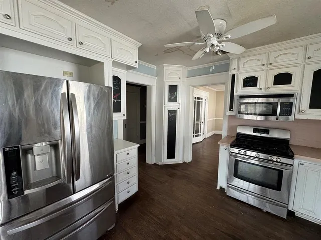 a kitchen with stainless steel appliances a stove a microwave and a refrigerator