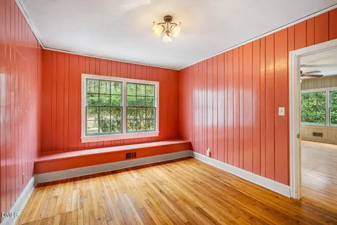 a view of a room with a large window and wooden floor