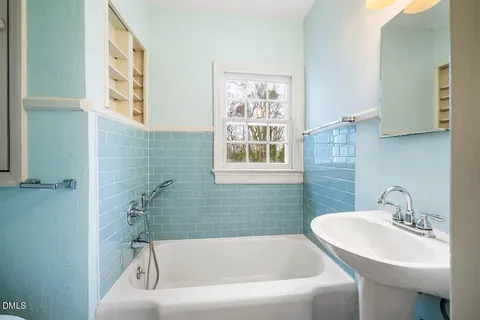 a white bath tub sitting next to a white sink