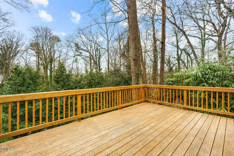 a balcony with wooden floor and trees
