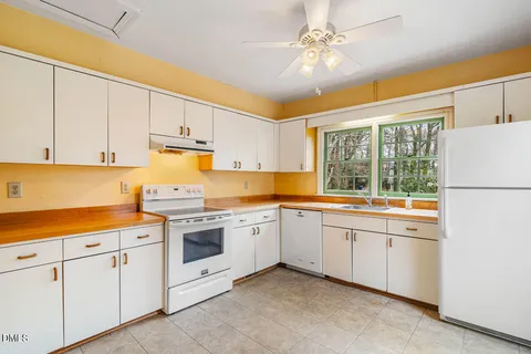 a kitchen with white cabinets and white appliances