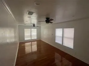 an empty room with windows and ceiling fan view