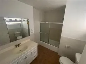a bathroom with a sink and mirror with toilet