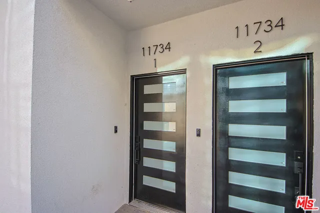 a living room with furniture and kitchen view with wooden floor