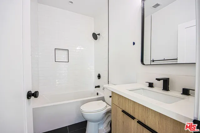 a bathroom with a sink toilet vanity and tub