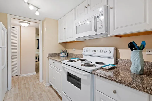 a kitchen with stainless steel appliances granite countertop a sink and a refrigerator