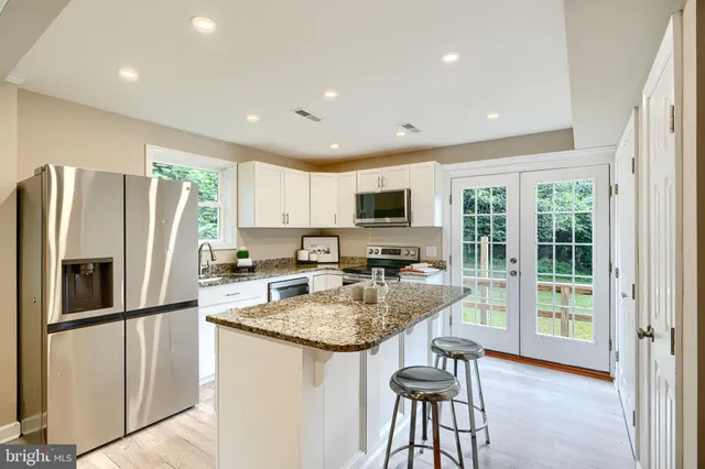 a kitchen with stainless steel appliances granite countertop a refrigerator stove microwave and sink