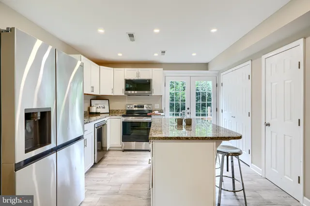 a kitchen with stainless steel appliances granite countertop a refrigerator a stove microwave and sink