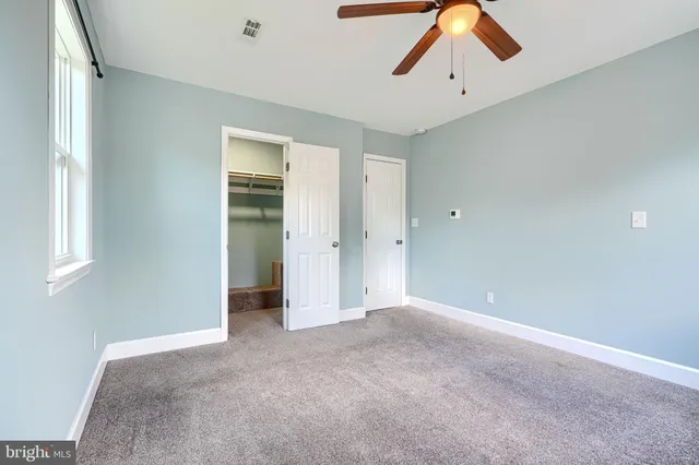 a view of empty room with ceiling fan