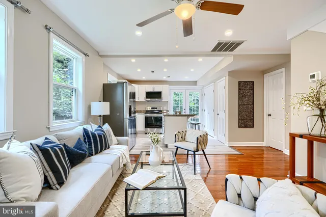 a living room with furniture and view of kitchen