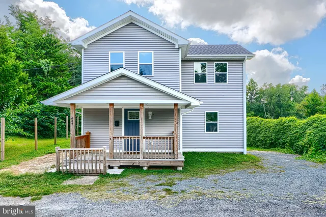 a front view of a house with a garden and deck