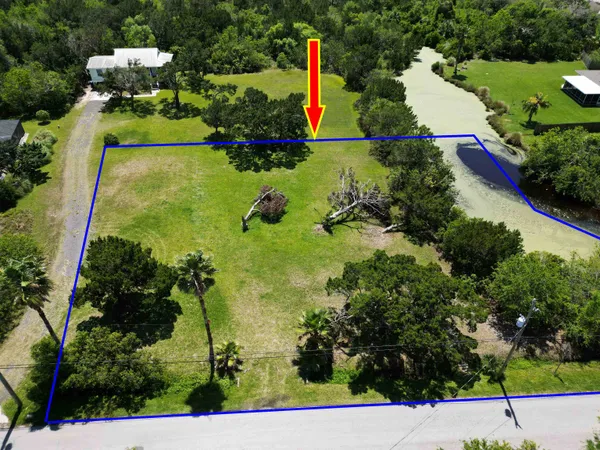 an aerial view of a house with a yard and lake view