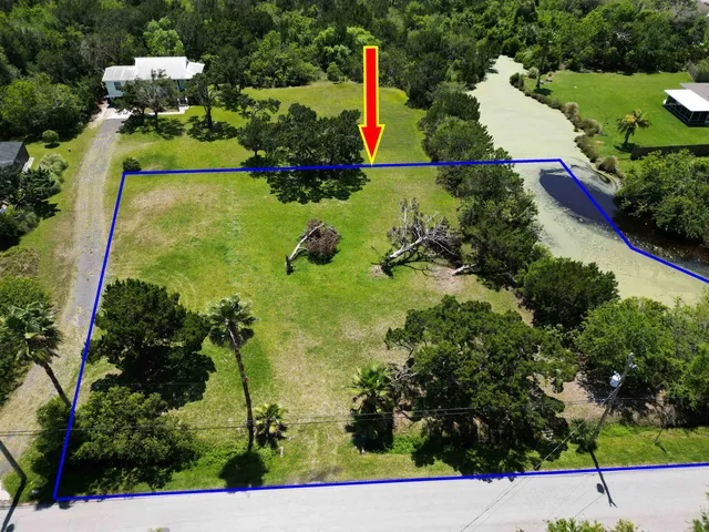 an aerial view of a house with a yard and lake view