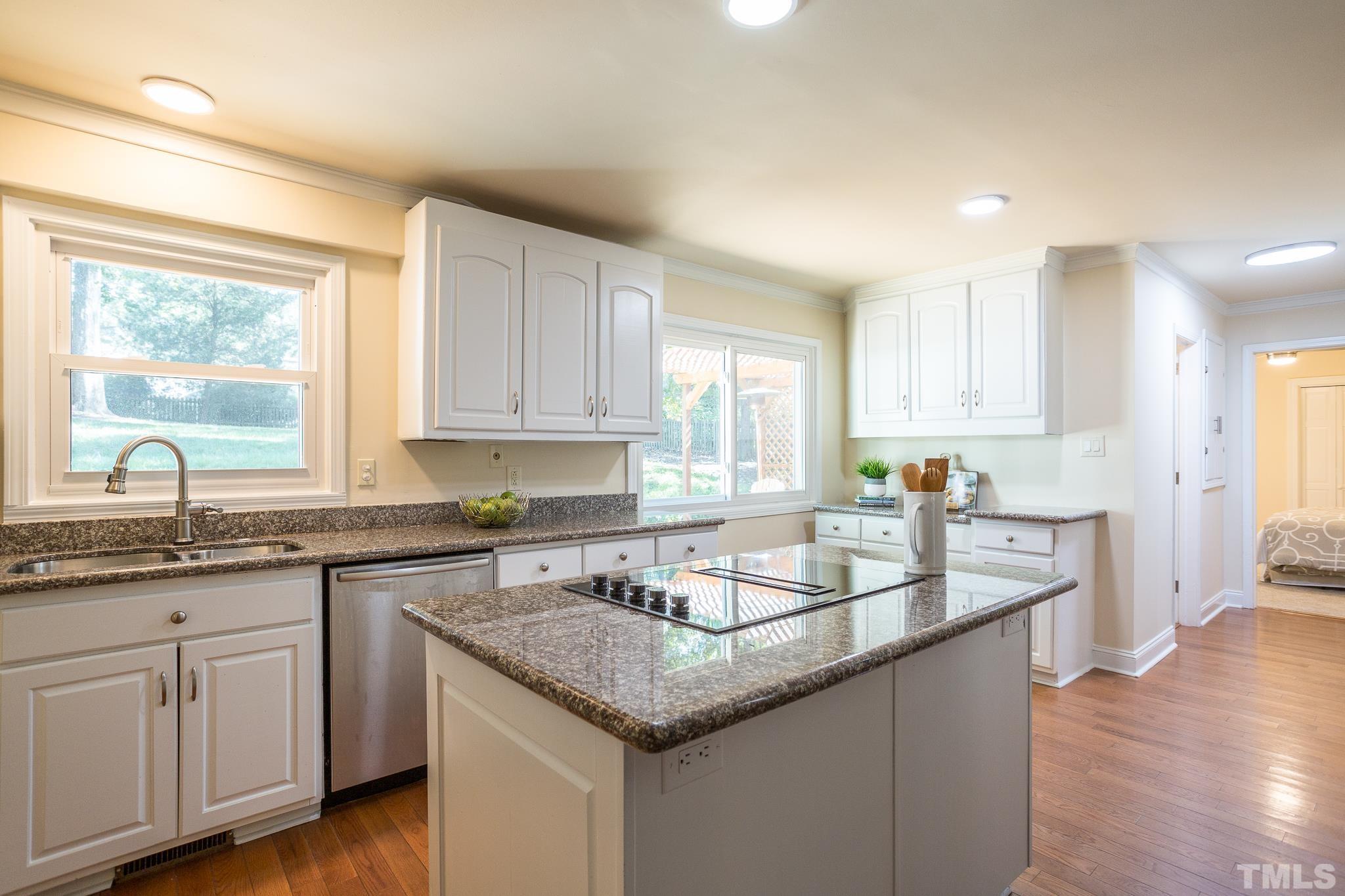 4608 Oak Park Road Raleigh, NC 27612 - Photo 8 of 30 a kitchen with granite countertop a sink and white cabinets