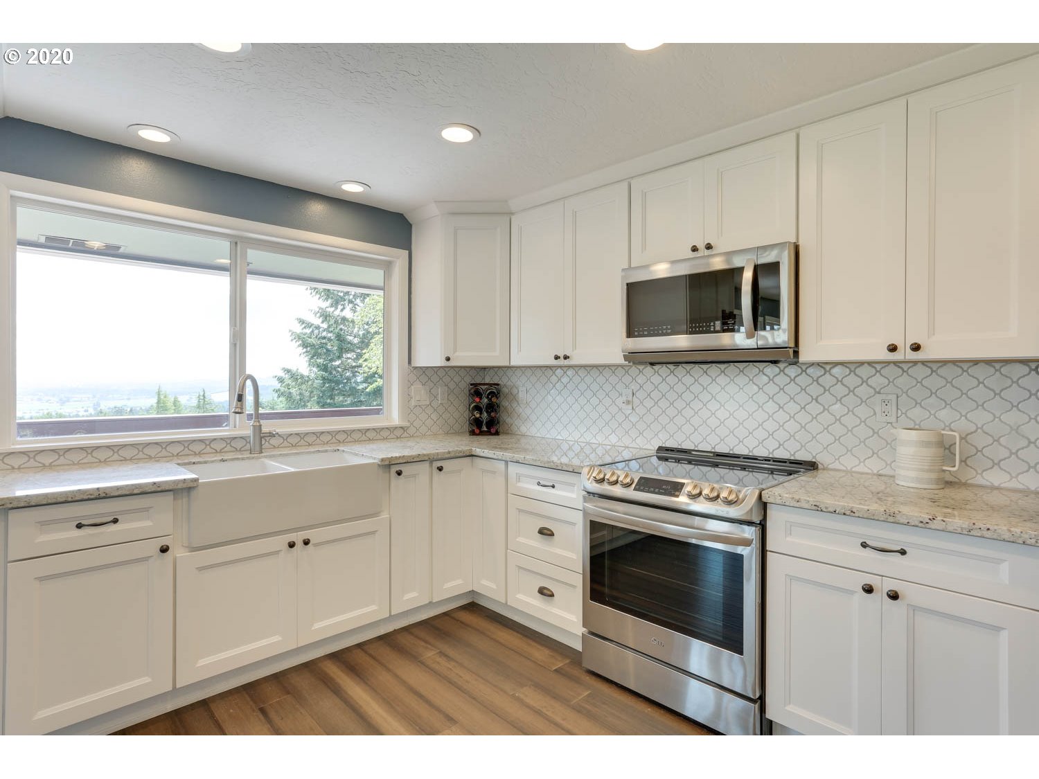33672 Southwest Laurel Road Hillsboro, OR 97123 - Photo 9 of 32 a kitchen with stainless steel appliances white cabinets and a stove top oven