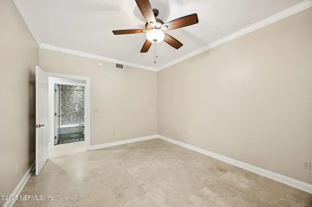 an empty room with windows and fan